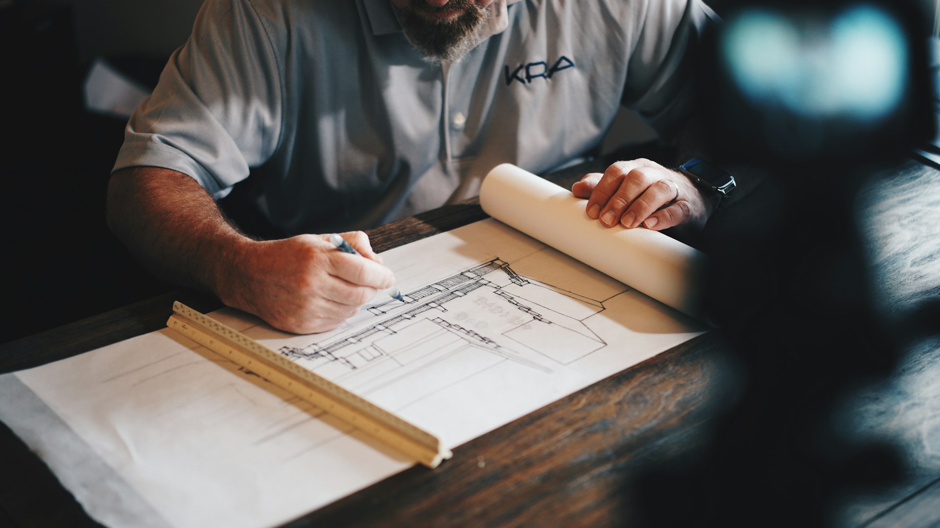 Architectural blueprint and ArchiCAD 3D design workspace.